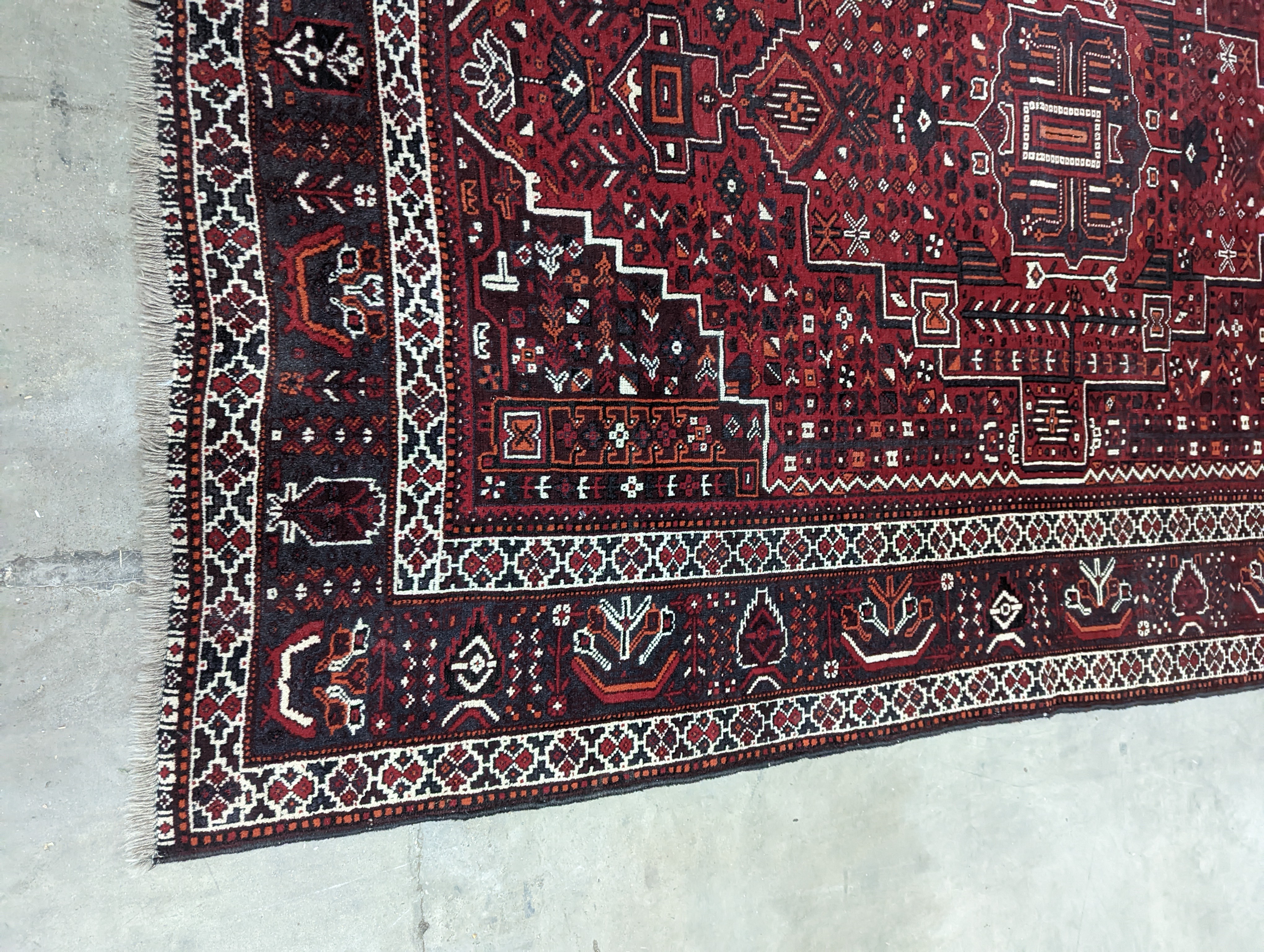 A Caucasian design burgundy ground carpet, 280 x 210cm